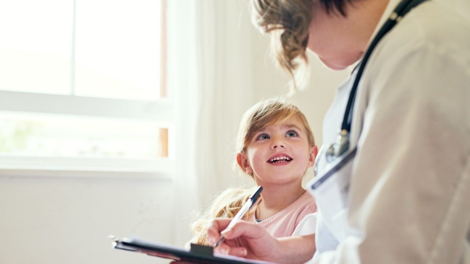 Медицинский специалист в белом халате со стетоскопом заполняет карту ребёнка рядом с улыбающейся девочкой у окна. Сцена иллюстрирует работу медсестёр с маленькими детьми — ключевой аспект спора о найме персонала в софийских яслях