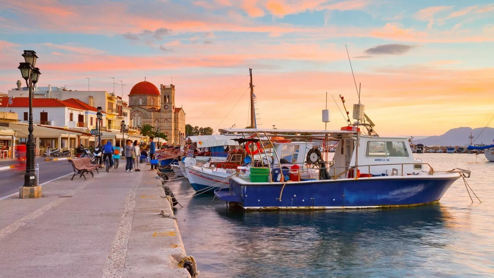 Порт острова Эгина на закате — рыбацкие лодки у набережной и купол церкви на фоне розового неба