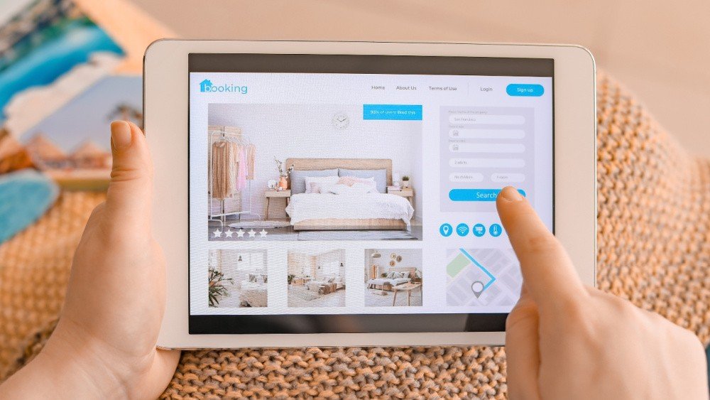 Турист просматривает сайт бронирования жилья на планшете — онлайн-платформы становятся основным каналом бронирования отпуска