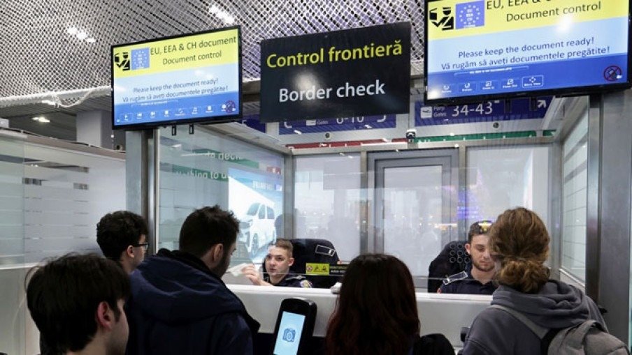 Пассажиры проходят пограничный контроль в аэропорту — табло с надписью «Control frontiera / Border check»