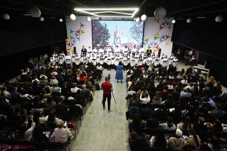 Церемония открытия олимпиады по английскому и испанскому языкам: зал заполнен участниками, на сцене выступает хор