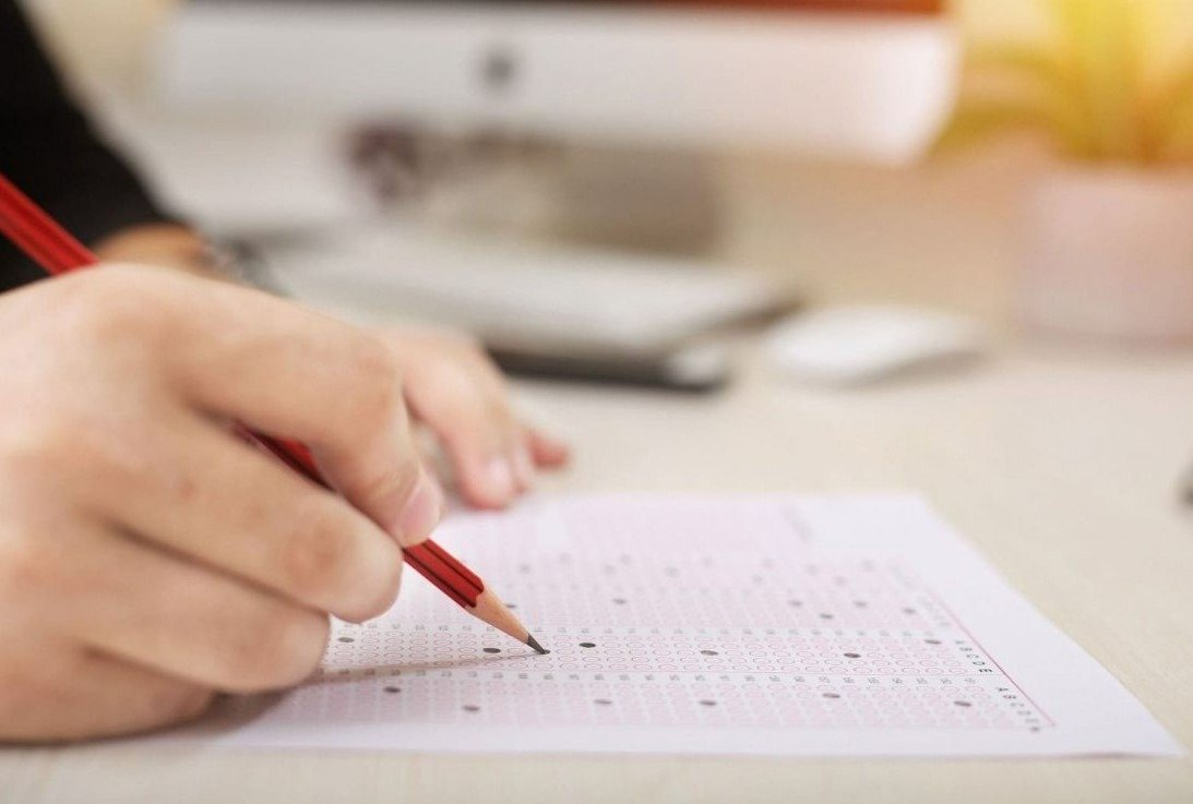 Ученик заполняет экзаменационный бланк карандашом во время выпускного экзамена