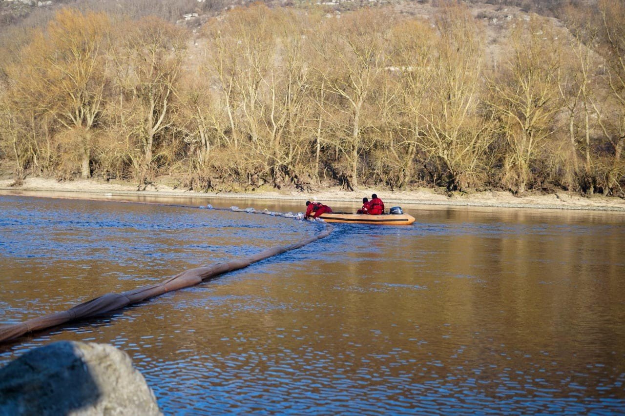 Нефтяной заградительный барьер на Днестре и спасательная лодка у места ликвидации загрязнения