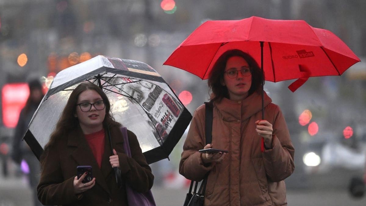 Прохожие с зонтами на городской улице в дождливую погоду — резкое ухудшение погоды затрагивает повседневную жизнь населения