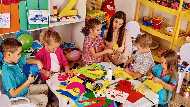 Воспитатель проводит занятие по аппликации с детьми в дошкольном учреждении