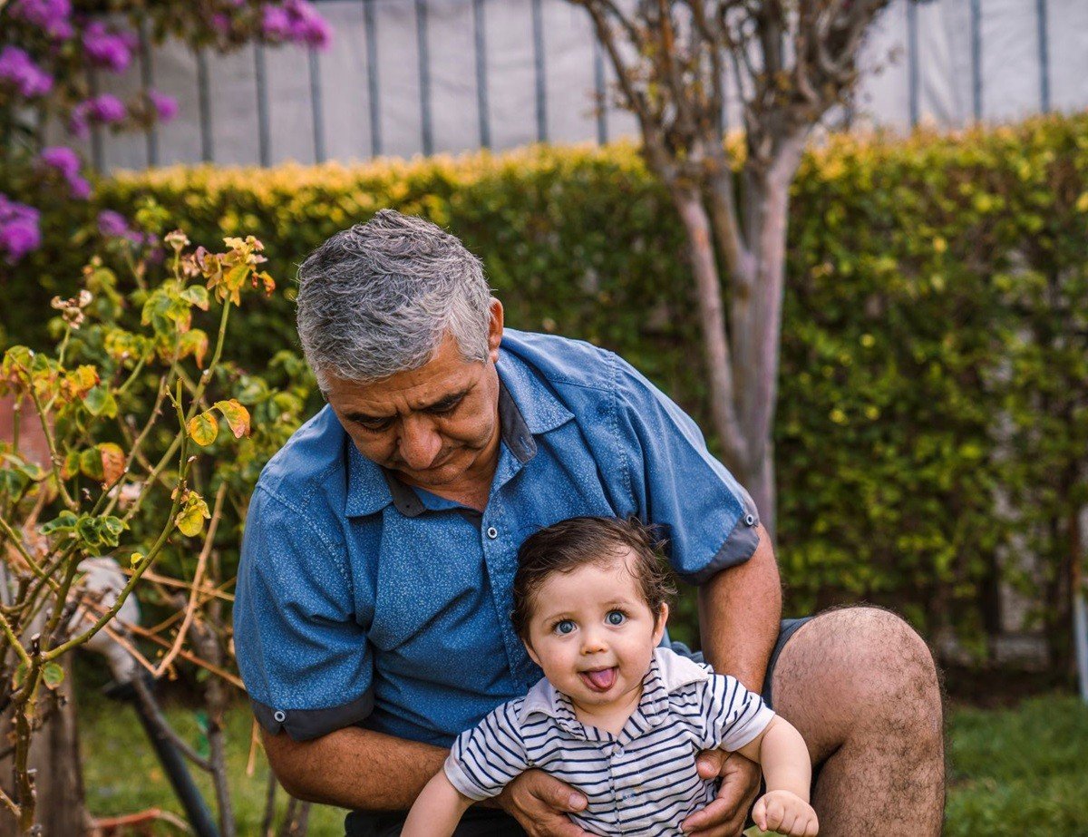 Пожилой мужчина с маленьким ребёнком в саду