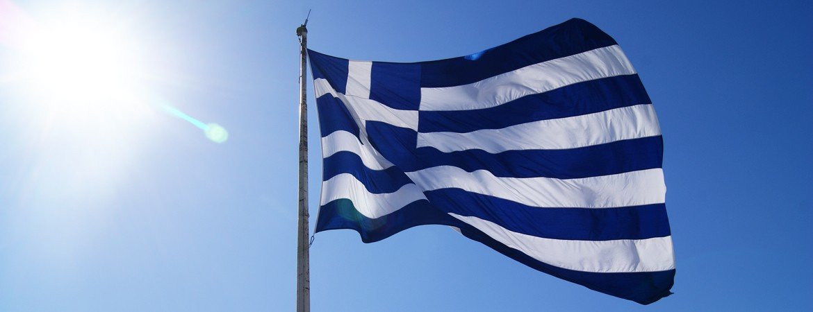 Греческий флаг развевается на фоне голубого неба — символ культурного фестиваля в Белграде