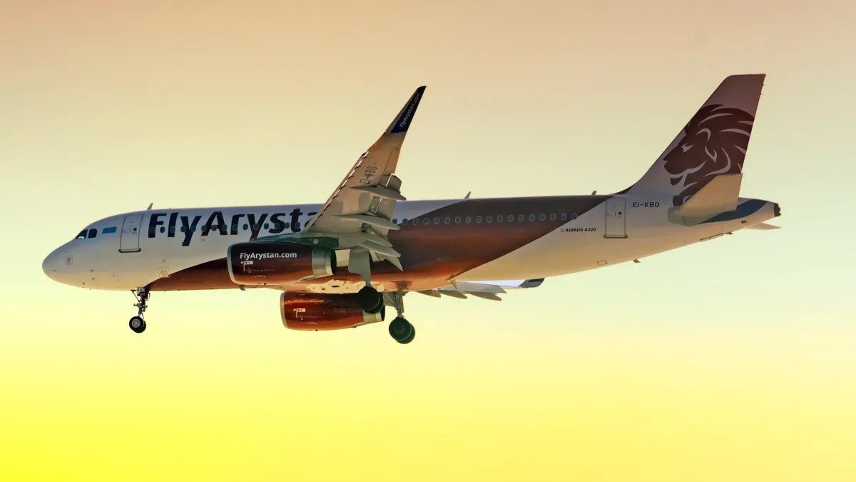 Самолёт Airbus A320 авиакомпании FlyArystan в полёте на фоне закатного неба