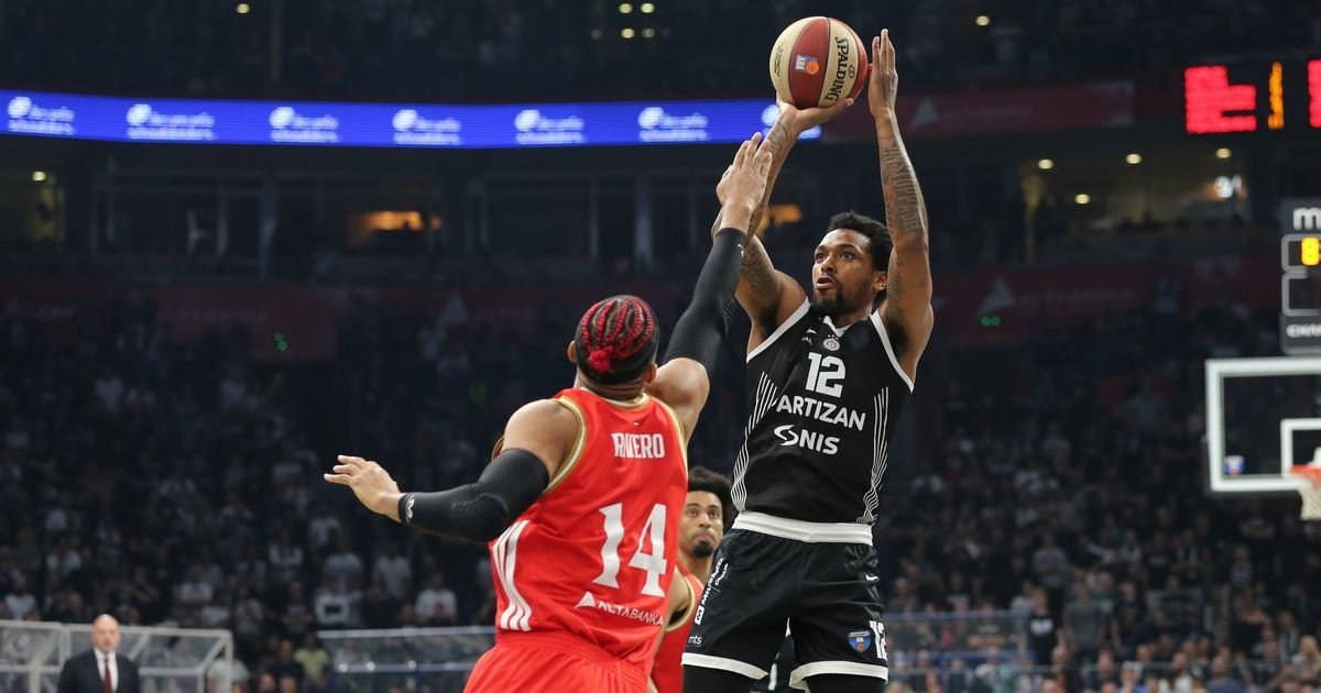 Защитник Партизана атакует кольцо броском в прыжке под прессингом Алена Риверо (№14) из Црвены Звезды в дерби АБА-лиги