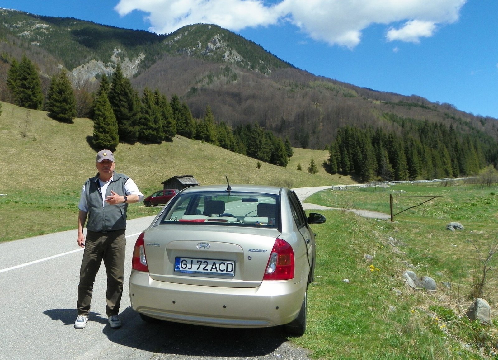 Исследователь на полевом выезде в карстовом районе Горжа: лесистые склоны и известняковые гребни Карпат на заднем плане