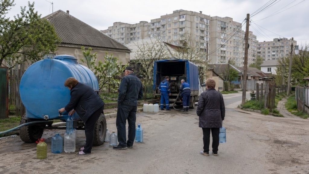 Жители Дурлешт с пластиковыми канистрами и бутылями стоят в очереди у синей цистерны Apă-Canal Chişinău — работники коммунальной службы раздают питьевую воду прямо на улице во время отключения водоснабжения