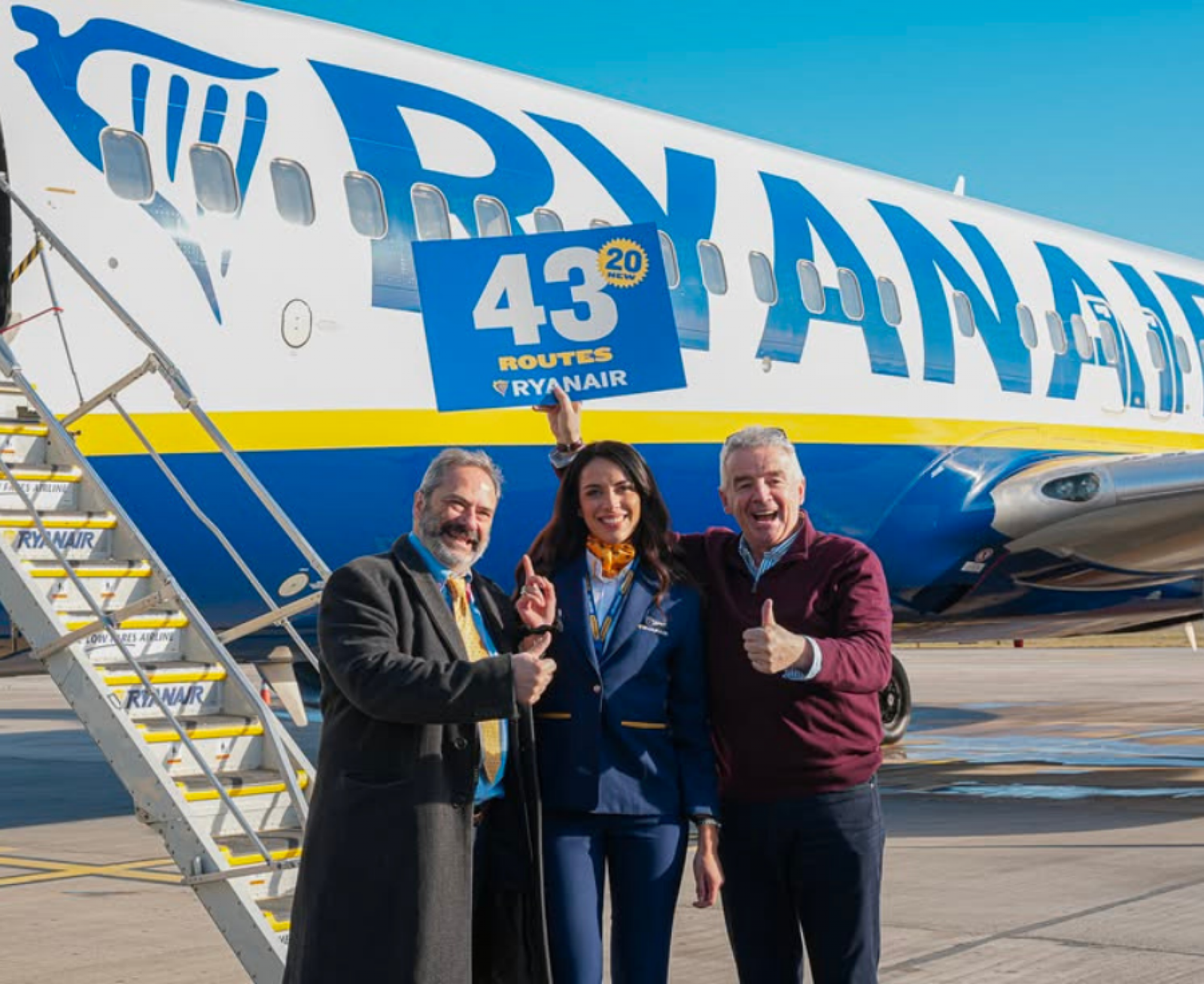 Представители Ryanair и аэропорта Тираны позируют на фоне Boeing 737 с надписью «43 маршрута» в международном аэропорту имени Матери Терезы