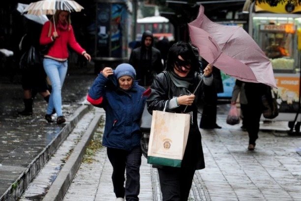 Прохожие укрываются от сильного ливня на улице Белграда