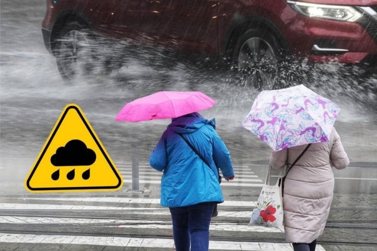 Пешеходы под зонтами во время сильного дождя — автомобиль поднимает брызги с мокрой дороги