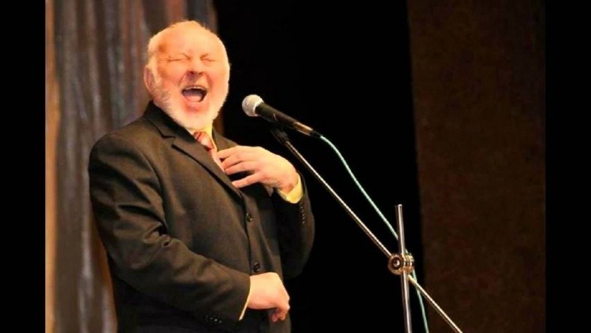 Георге Урски выступает на сцене с микрофоном