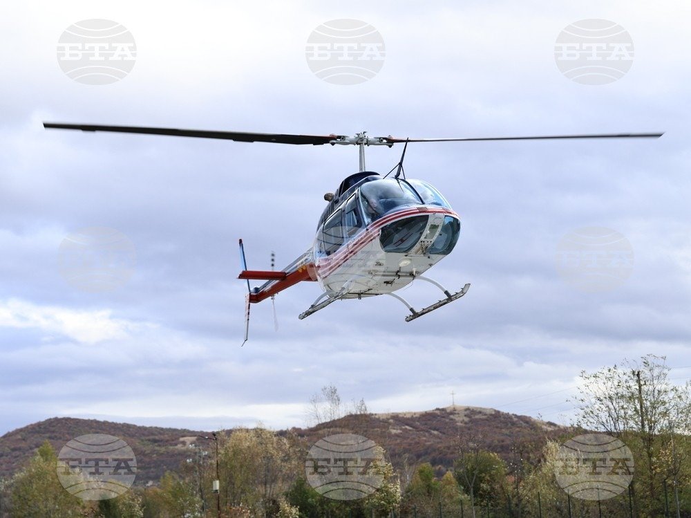 Медицинский вертолёт в полёте над холмистой местностью