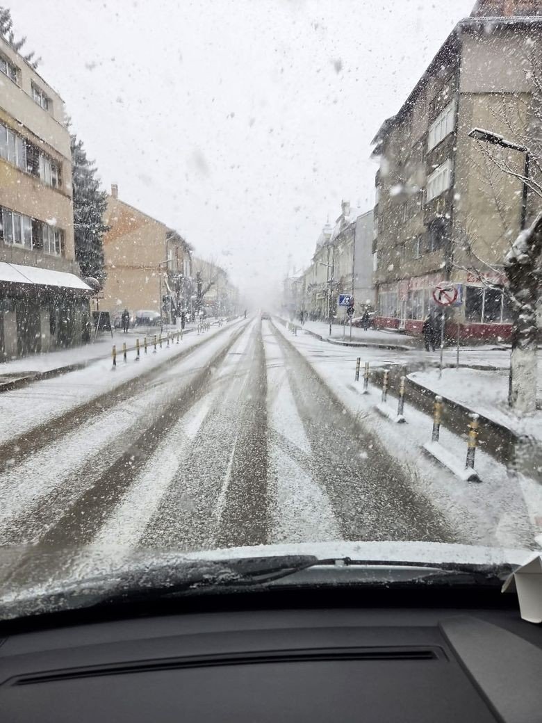 Сильный снегопад на улицах румынского города 9 апреля 2026 года, вид из автомобиля