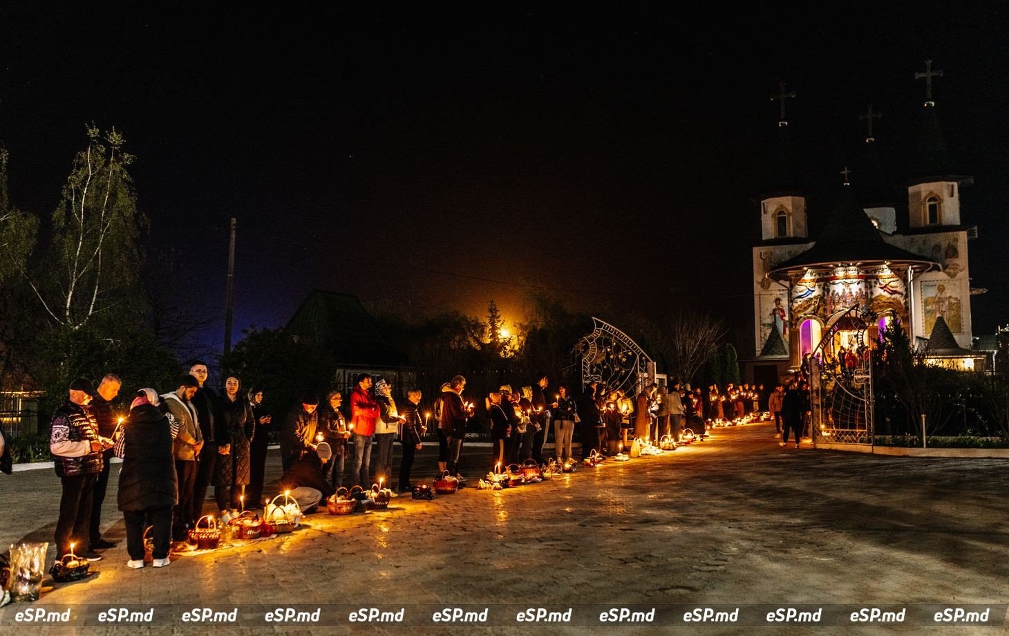 Верующие со свечами у церкви во время пасхального ночного богослужения
