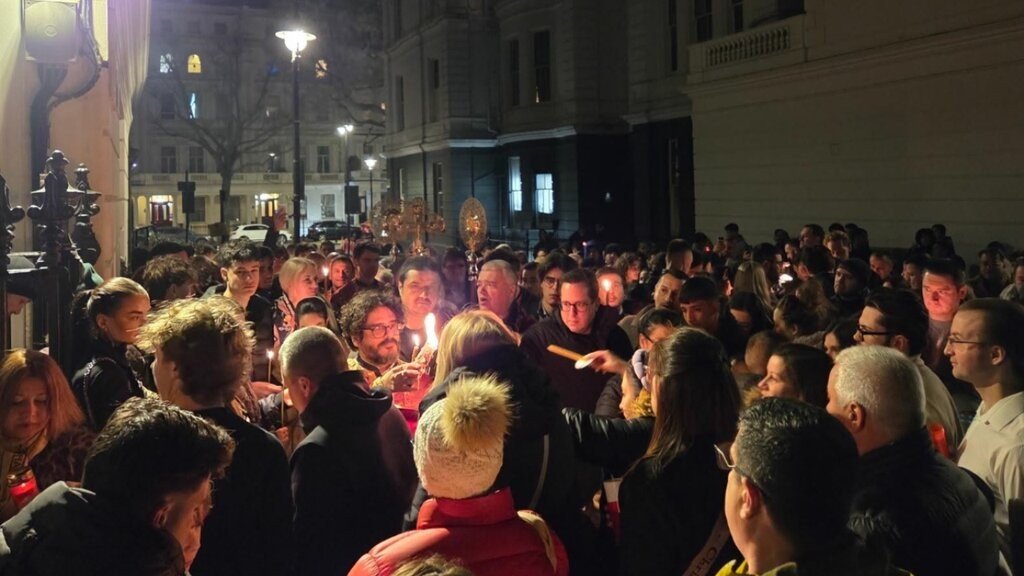 Верующие со свечами у храма на ночном пасхальном богослужении