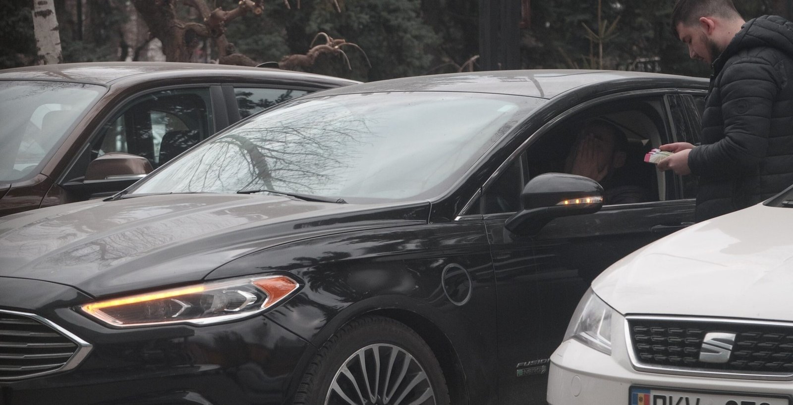 Кадр скрытой съёмки уличной передачи упаковки электронных сигарет Elf Bar у автомобиля в Кишинёве