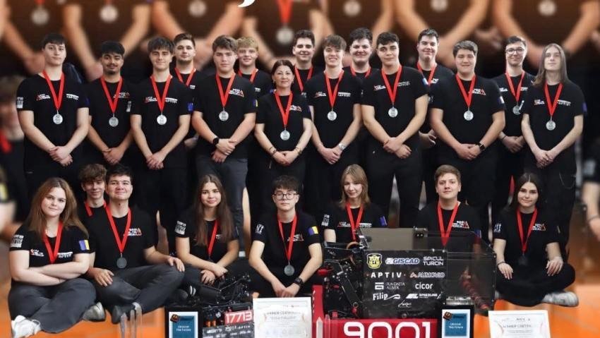 Полный состав команды Delta Force в серебряных медалях и командных футболках вокруг боевого робота №9001 на фоне логотипов спонсоров — Aptiv, Giscad, Cicor, Fundația Alber