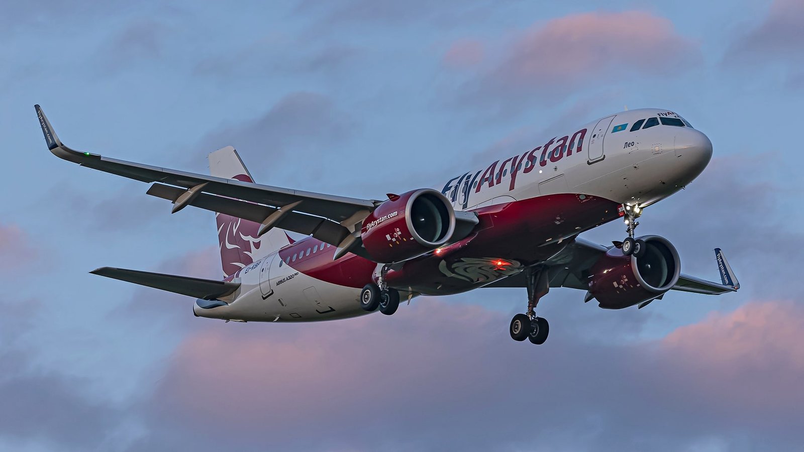 Самолёт FlyArystan A320neo заходит на посадку в сумерках с выпущенными шасси
