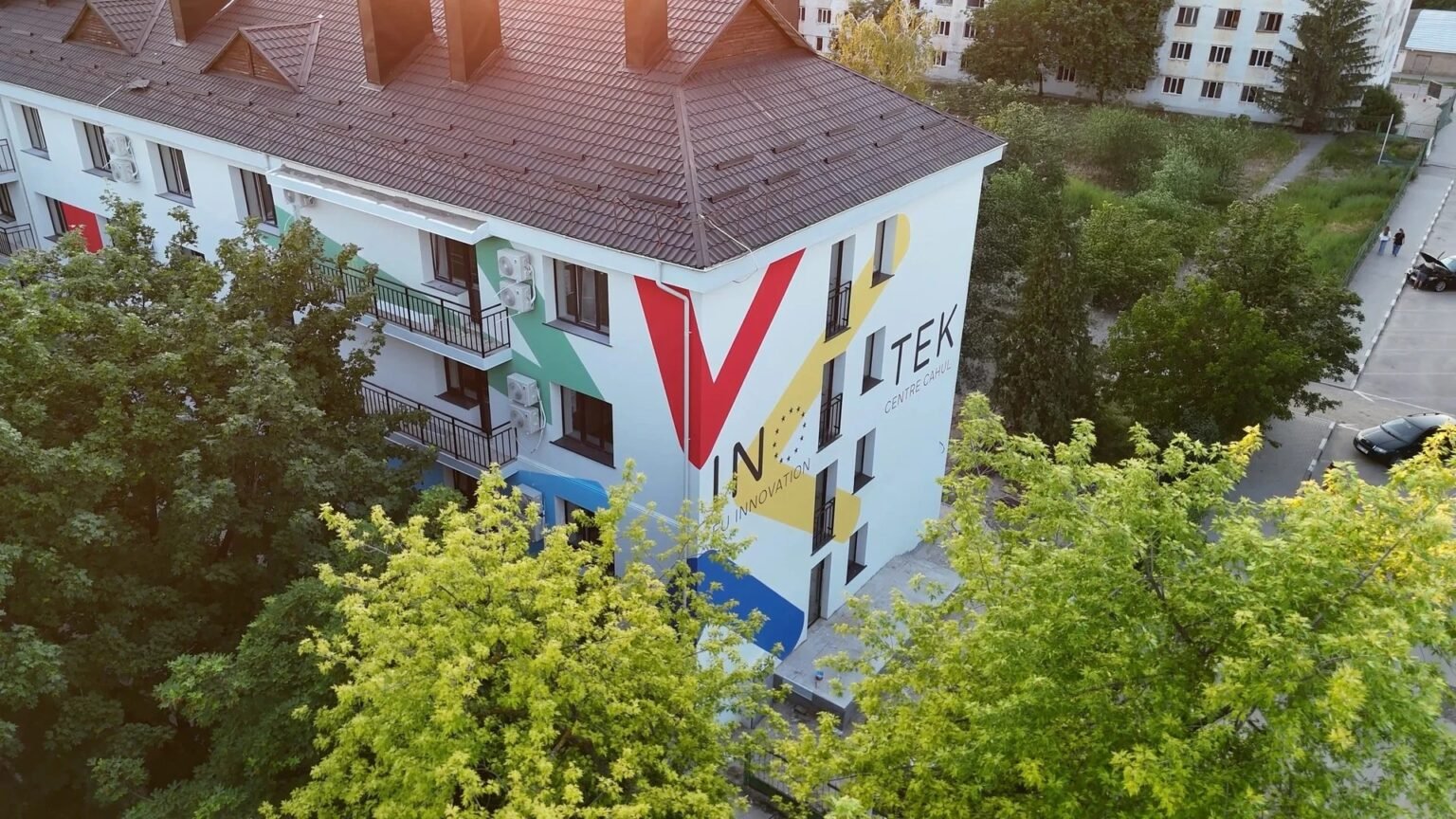 Вид с дрона на здание центра Inotek — EU Innovation Centre в Кагуле с расписным фасадом в фирменных цветах среди зелени южной Молдовы