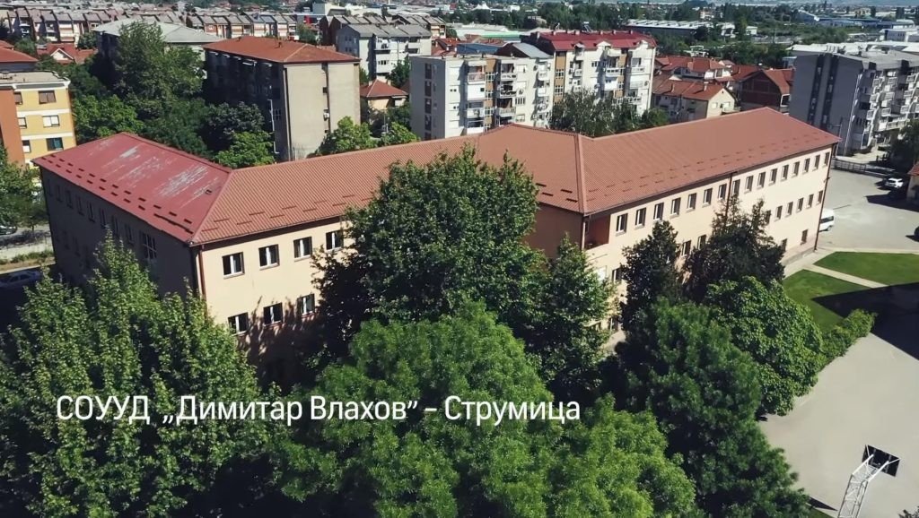 Здание СОУУД &laquo;Димитар Влахов&raquo; в Струмице с воздуха: учебный корпус с красной крышей в окружении жилых кварталов