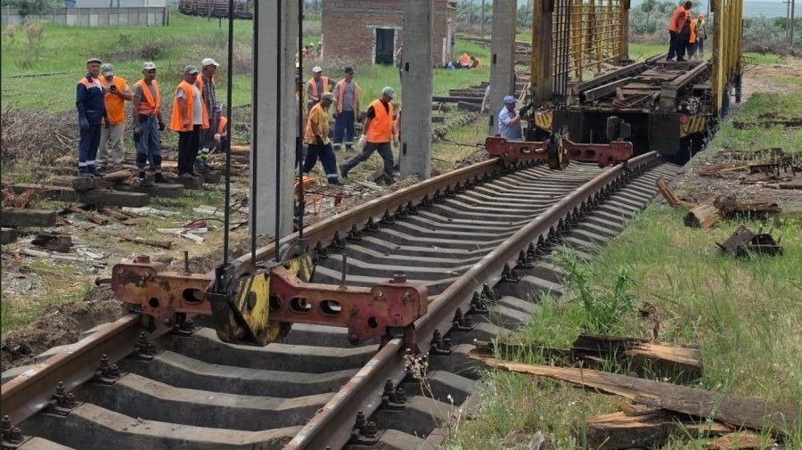 Рабочие укладывают железнодорожные пути на модернизируемом участке молдавской железной дороги