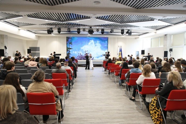 Зал Педагогического университета имени Иона Крянгэ во время церемонии открытия Республиканской олимпиады по румынскому языку — участники наблюдают за выступлением на сцене