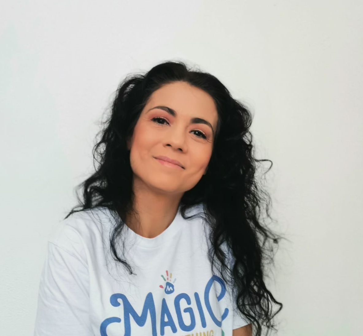 Сотрудница Ассоциации Magic в белой футболке с логотипом организации