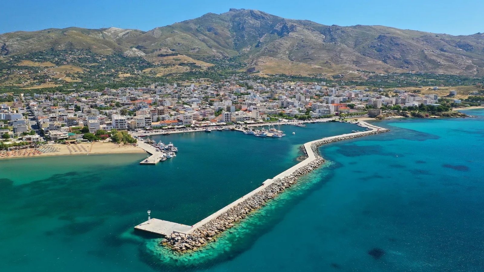 Аэрофотоснимок Каристоса на острове Эвбея — город, порт и бирюзовое море у подножия горы