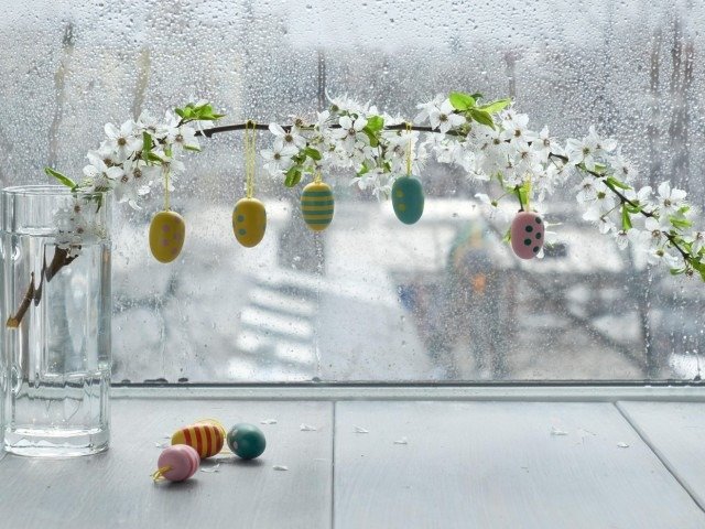Пасхальные яйца на цветущей ветке на фоне дождливого окна — Пасха 2026 года в Румынии омрачена непогодой