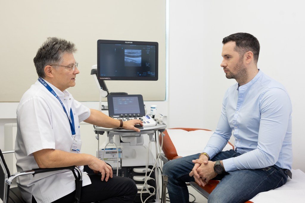 Врач консультирует пациента рядом с аппаратом ультразвуковой диагностики