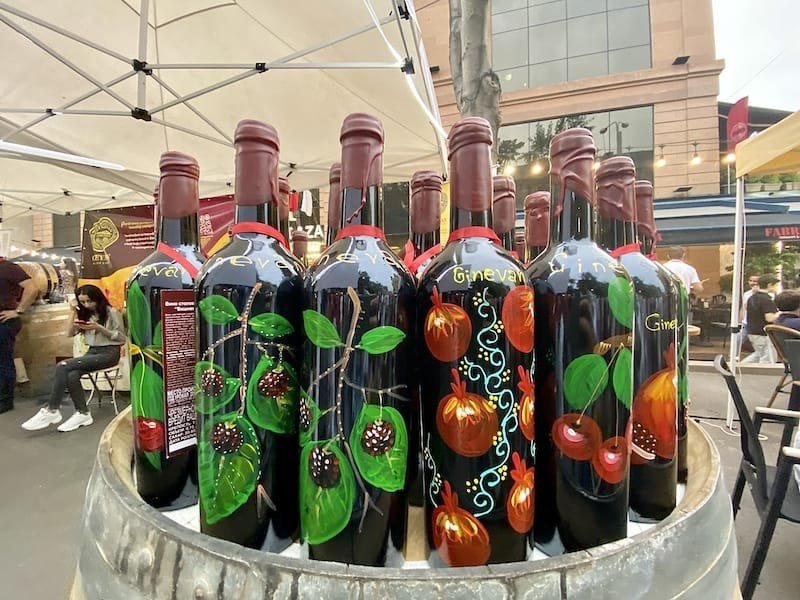 Бутылки армянского вина с ручной росписью на бочке во время фестиваля Yerevan Wine Days