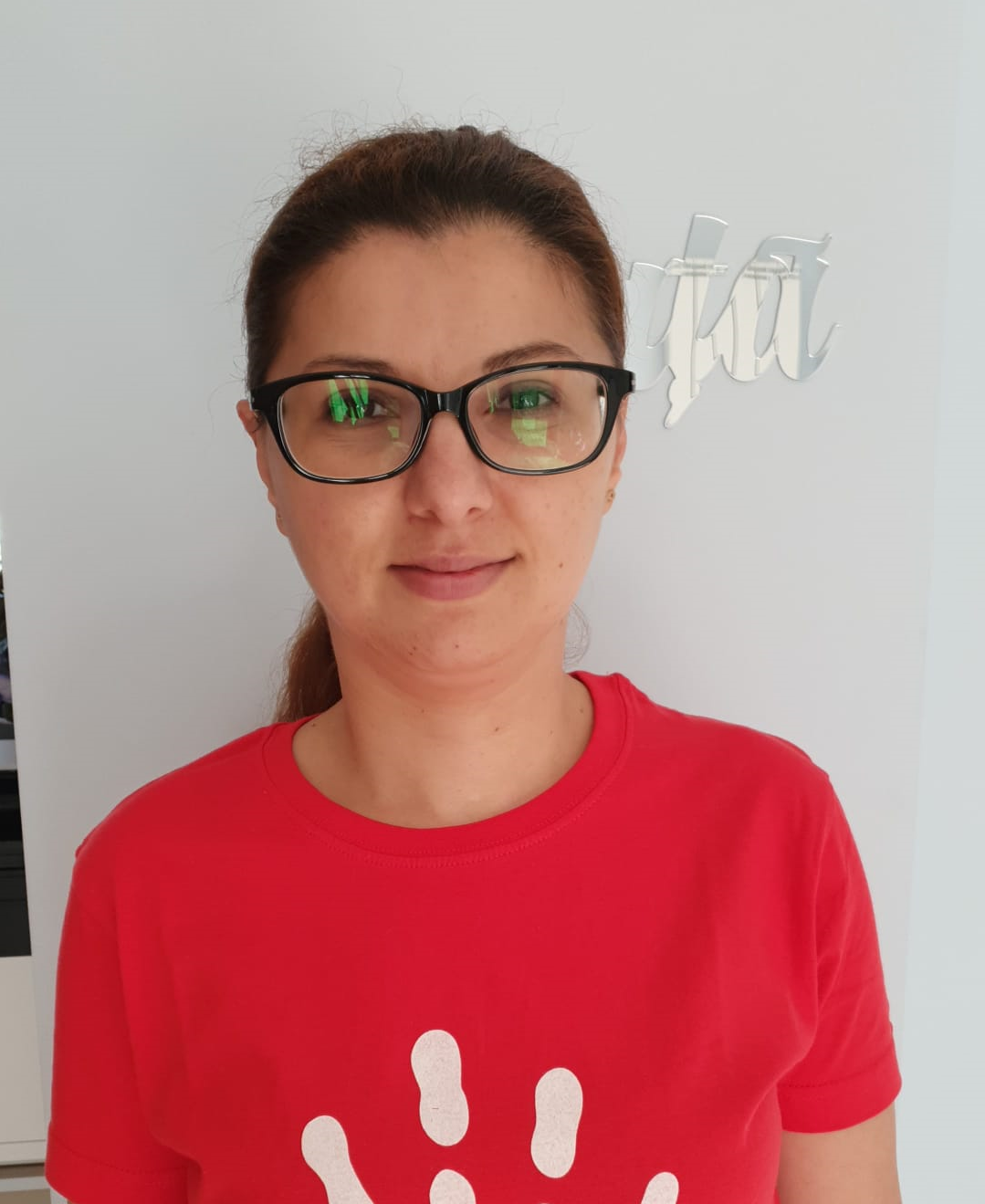 Сотрудница Ассоциации Magic в красной футболке с логотипом-ладошкой