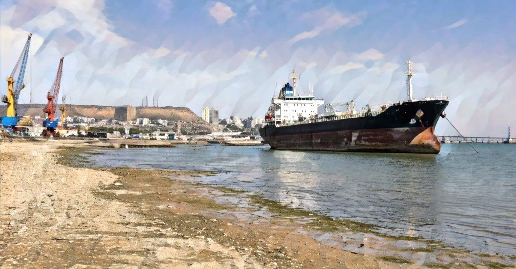 Грузовой корабль у обмелевшего каспийского берега рядом с портовыми кранами
