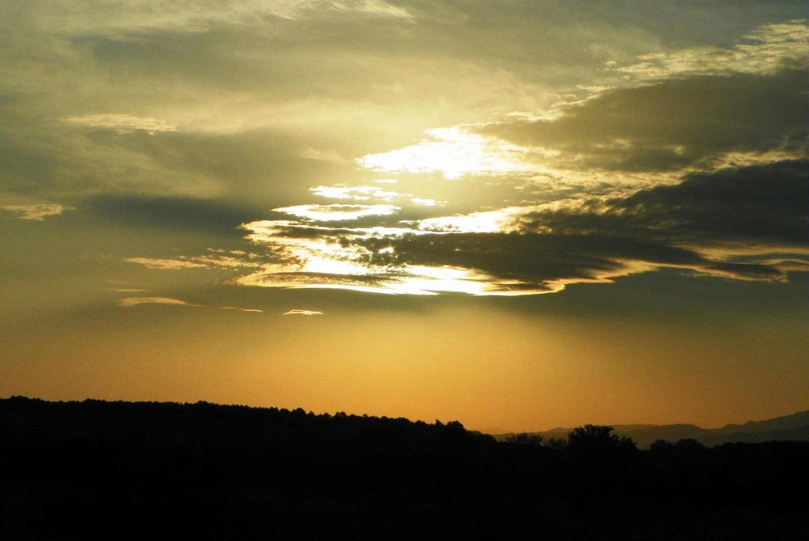 Закат над лесистыми холмами уезда Горж — карстовый регион на южном склоне Румынских Карпат в вечернем свете