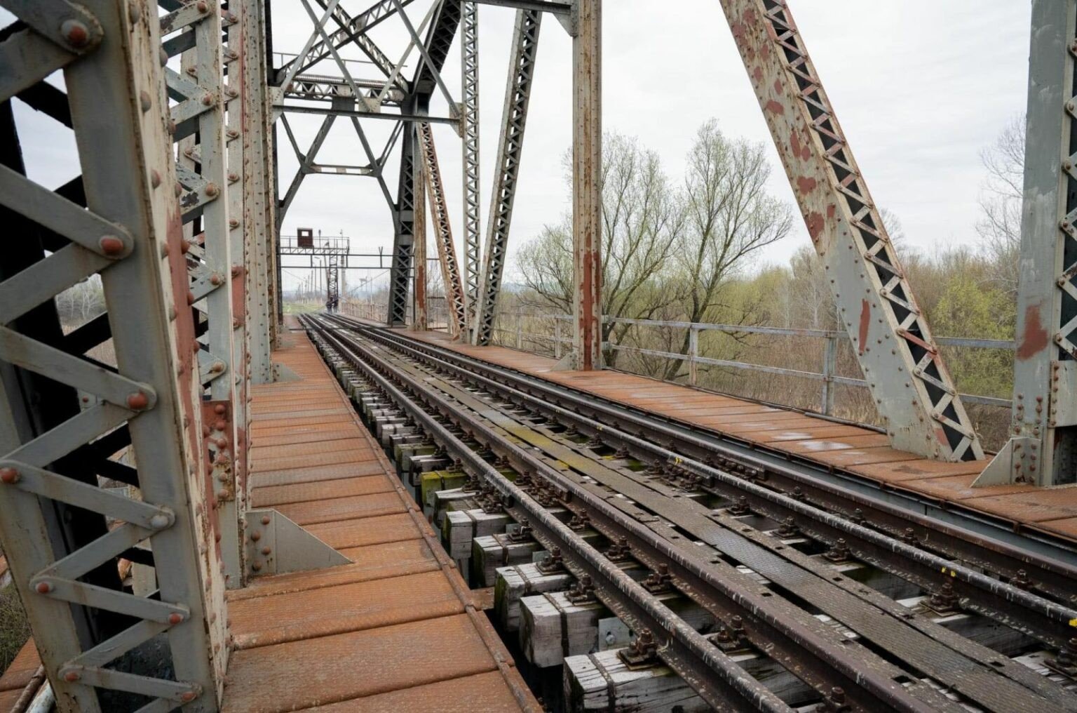 Металлическая конструкция моста и рельсы внутри железнодорожного моста через Прут
