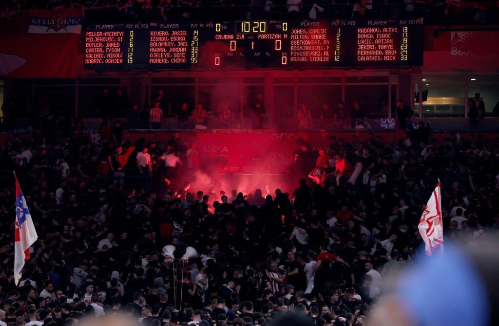 Болельщики зажигают файеры на трибунах во время белградского дерби, на табло отображается счёт матча