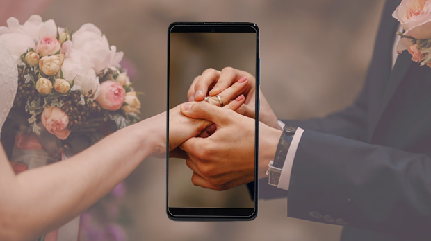 Свадьба по клику: Сербия спрашивает граждан о цифровизации Обмен обручальными кольцами, показанный через экран смартфона, — символ перехода свадебных процедур в цифровой формат