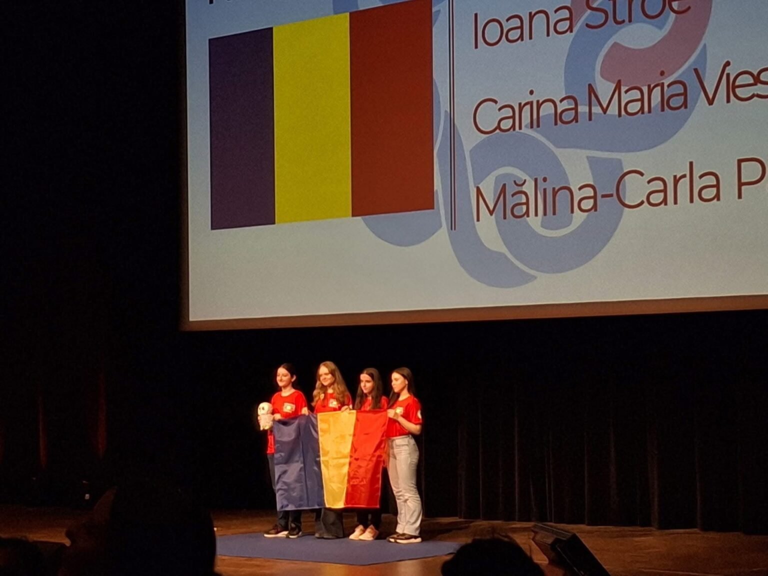 Четыре школьницы из Румынии с национальным флагом на церемонии награждения EGMO 2026 в Бордо