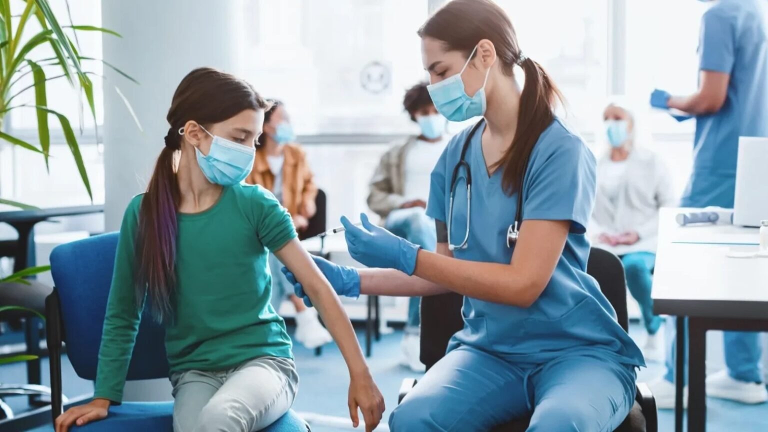 Медсестра делает прививку девочке-подростку в кабинете поликлиники