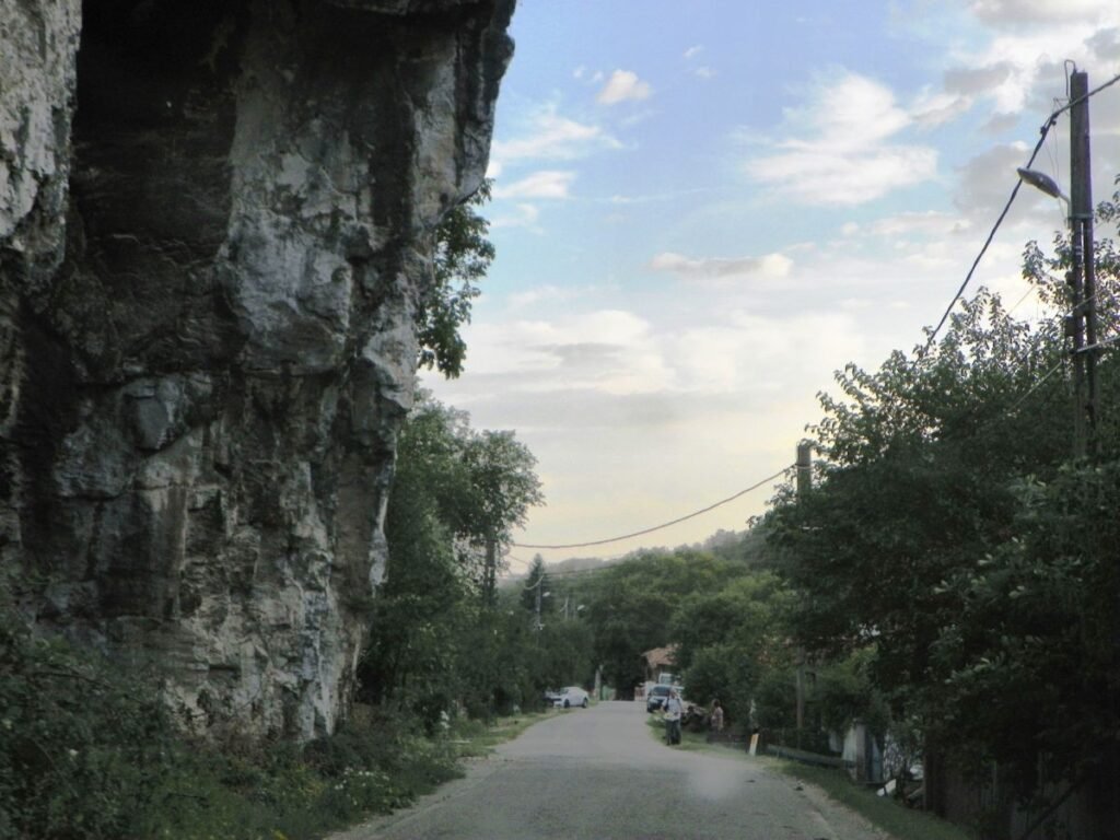 Известняковый утёс возвышается над просёлочной дорогой на окраине села в уезде Горж — типичный карстовый выход на поверхность в южных Карпатах