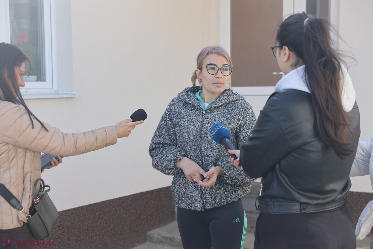Жительница Молдовы даёт интервью журналистам на фоне утеплённого жилого дома в рамках национальной программы энергоэффективности