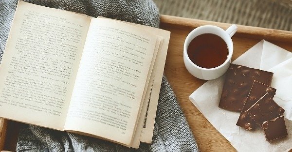 Первый европейский литературный фестиваль пройдёт в Белграде Раскрытая книга на уютном пледе рядом с чашкой чая и кусочками шоколада на деревянном подносе