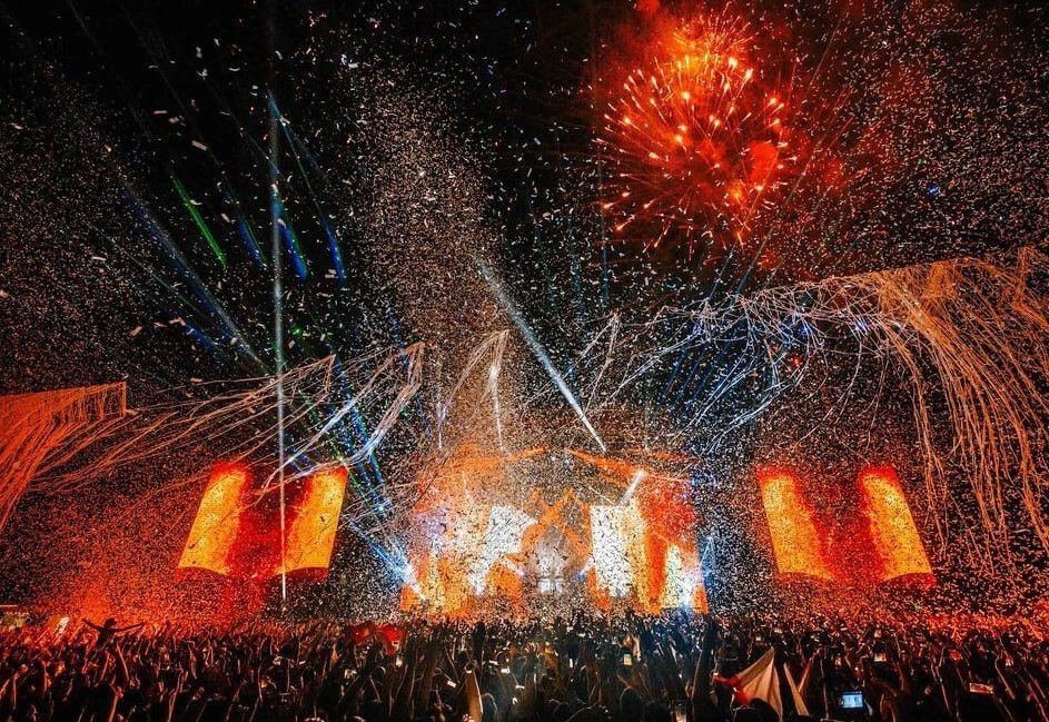 EXIT переезжает из Нови-Сада в черногорский Ульцинь Ночная сцена фестиваля EXIT с фейерверками, конфетти и сценическим освещением над толпой зрителей на Петроварадинской крепости