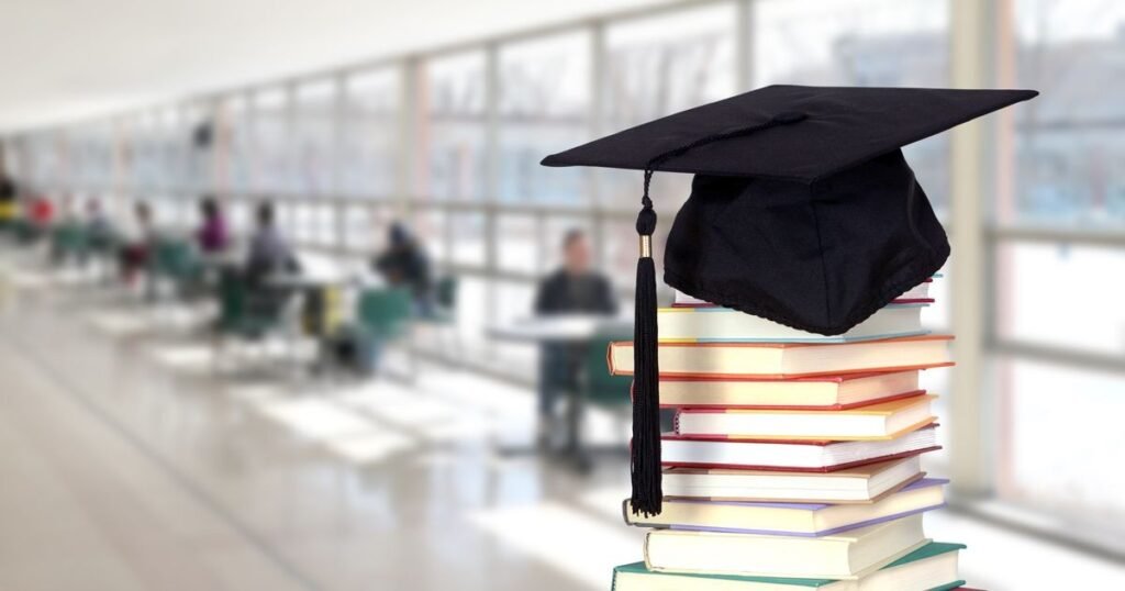 Академическая шапочка на стопке книг в светлой библиотеке