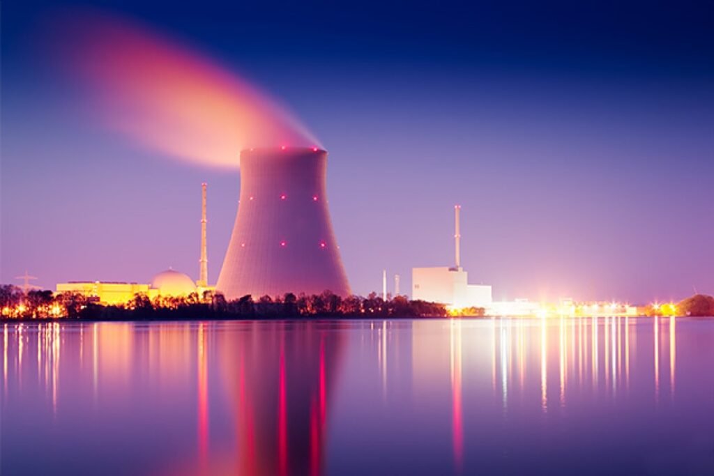 Атомная электростанция на закате с отражением огней в воде