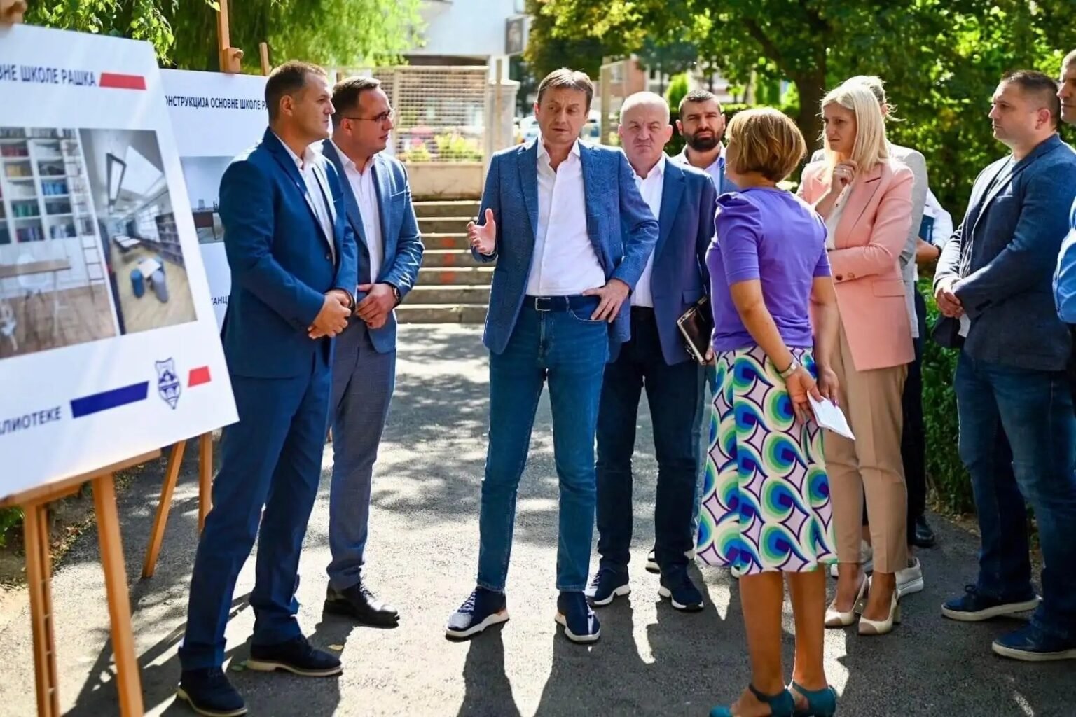 Чиновники осматривают стенды с проектом реконструкции школы «Рашка»